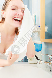 洗脸的女人在浴室用清洁水洗脸图片