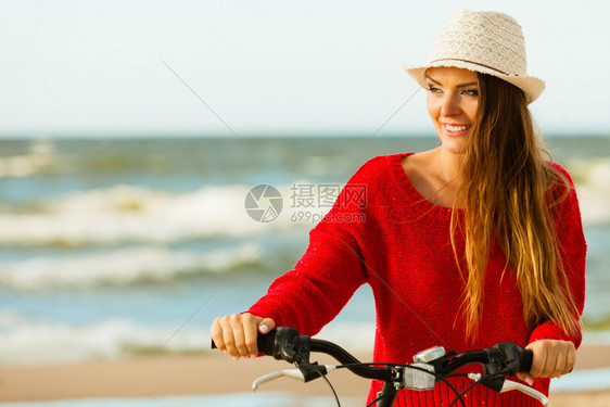 在海边骑自行车的年轻活跃女孩夏天在海上附近躺着笑的可爱女人时装旅游者在新鲜空气中时装女孩在户外骑自行车图片