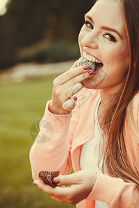 甜食和美味的点食和美味的餐后甜点美的有饼干蛋糕女人快乐笑女孩在户外吃小蛋糕图片