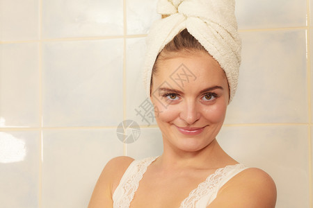 早上在浴室洗完澡后年轻女子在浴室洗完澡后美丽的女在浴室用毛巾蒙住头妇女用毛蒙住头部图片