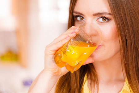 家中厨房的妇女饮用自制橙汁料健康食素减肥和人的概念厨房妇女饮用新鲜橙汁图片