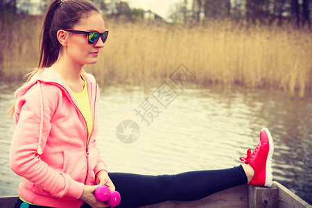 运动和活概念具有吸引力的女子在户外伸展年轻有积极女孩在湖岸上接受运动服装培训女孩在湖岸上接受运动服装培训图片