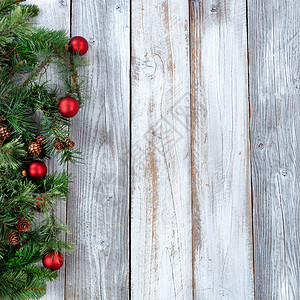 圣诞节背景白生木上有长绿树枝和红装饰品图片