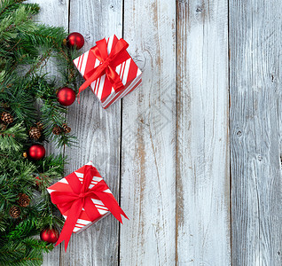 圣诞背景白生木上长绿色树枝礼品和红装饰图片