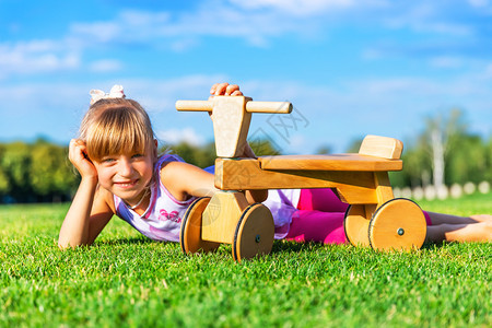 在草地上躺着的小女孩和木自行车图片