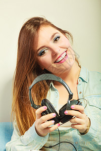 快乐的女子大耳机听音乐放松背景图片
