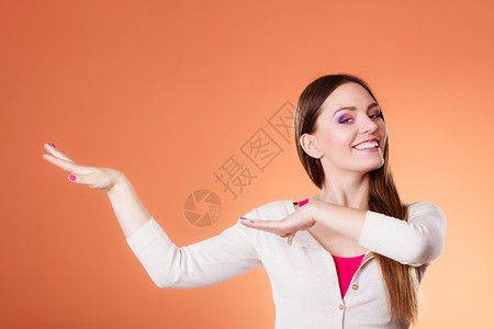 女人长的直发彩色的化妆舞会以橙色背景拍摄的演播室图片