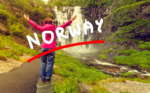 自由旅行的游妇女举起双臂向挪威沃斯县与格兰温霍尔达县之间Skjervsfossen瀑布看望Skjervsfossen瀑布由Skj图片
