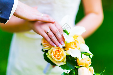 已婚夫妇新娘和郎手上带有选择焦点效果的金婚环戒指宏观点图片