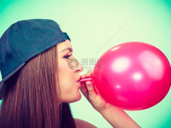 青少年和聚会为庆祝做准备特伦迪少女吹红气球年轻美女为派对准备配件青少年女孩吹红气球图片