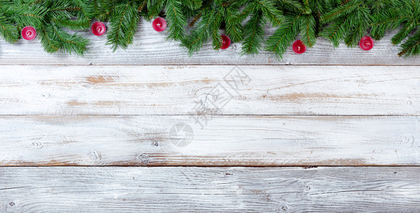 圣诞长绿树枝和白上红蜡烛的顶端边界图片