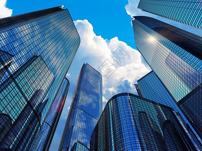 市中心公司商业区建筑概念玻璃反射办公大楼的玻璃反射用云和阳光遮挡蓝色天空的摩大厦图片