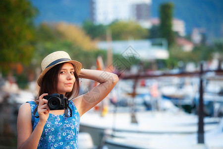 年轻有吸引力的快乐旅行女孩在旧地中海城市滨带相机走在旧地中海城市滨上图片