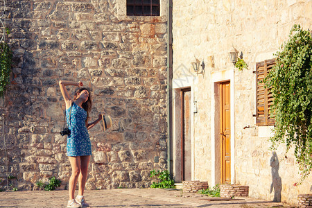 年轻有吸引力的旅行女孩在地中海老城与相机一起行走夏季旅概念黑山布德瓦年轻有吸引力的旅行女孩在地中海老城与相机一起行走夏季旅概念图片