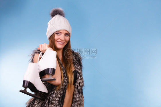 穿着黑色胸罩温暖的帽子和毛衣外冰溜蓝背景工作室拍摄图片