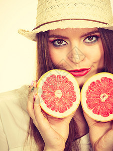 女有吸引力的长头发女多彩的双眼化妆将两半的葡萄果柑橘水握在手中健康饮食暑假欢乐概念过滤照片女将两半的葡萄果柑橘水握在手中图片