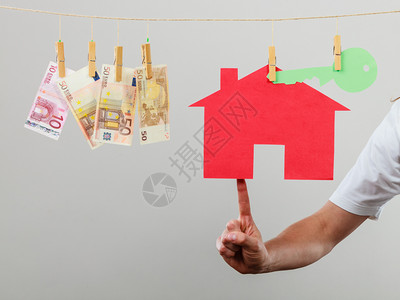 房地产和交易概念售卖人手持房屋模型和货币钞票出售和购买提议图片