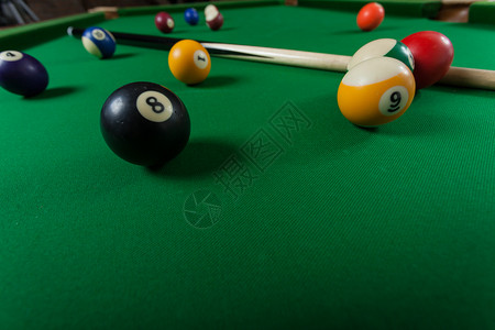 Billiard球和杆粘在绿色桌上池球游戏史努克和坚持在台桌上图片