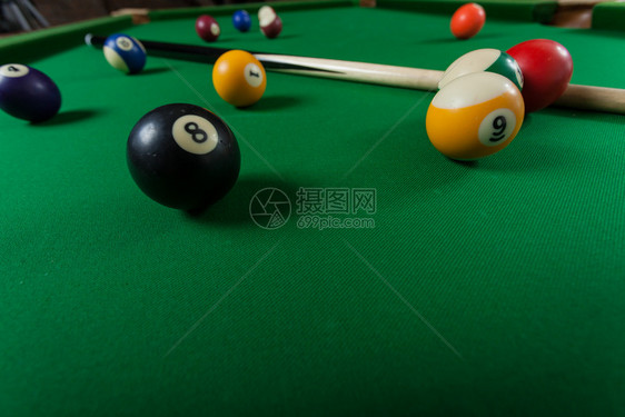 Billiard球和杆粘在绿色桌上池球游戏史努克和坚持在台桌上图片