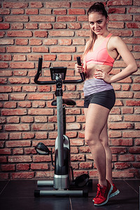 女生在健身房运动自行车训练瘦身减肥图片