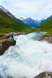 旅行自然美的丽旅游女在挪威观看Videfossen称为Buldrefossen瀑布图片
