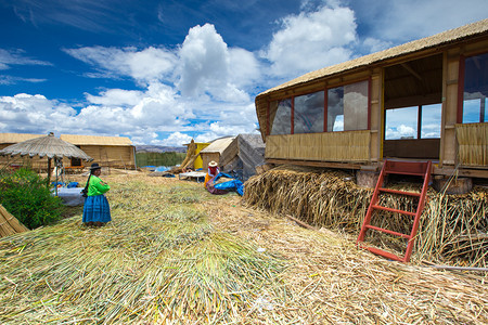 PERU2015年月日205年月日不明身份的穿传统服装妇女欢迎乌罗斯岛的游客图片