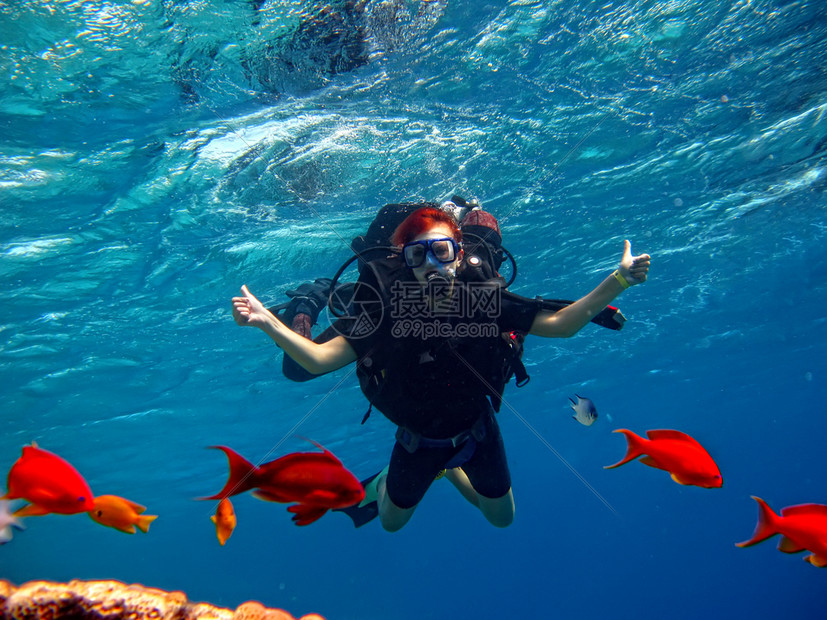 一名少女第次在潜水设备中与一名游泳教练起跳入大海在珊瑚礁附近图片