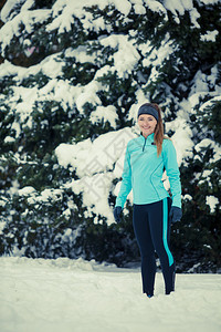 运动冬季人的概念年轻女士在公园里锻炼美丽的女孩在外面跑步享受旋转时光穿着蓝色顶部和腿的妇女在公园里锻炼的年轻女士图片