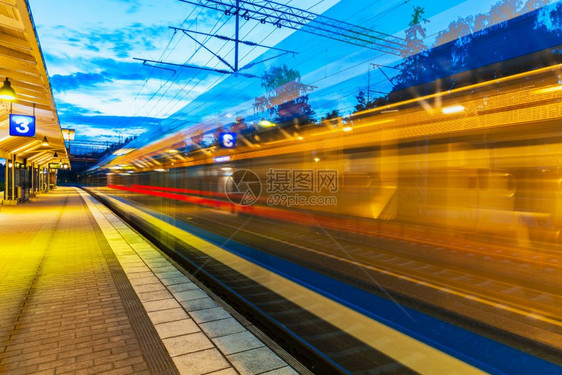 铁路旅行和运输业商概念从火车站平台驶离的高速往返客运列车夏季夜视运动效果模糊图片