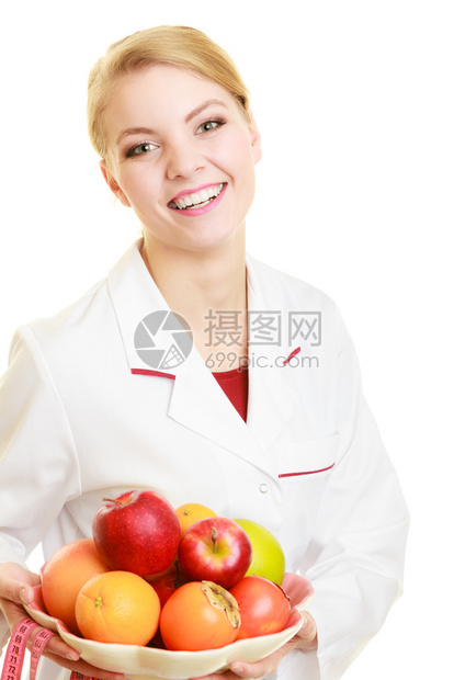 身穿白色实验室大衣带水果和多彩度量磁带的近身妇女被隔离图片