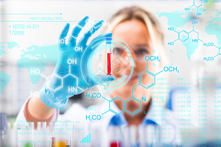 科学化研究实验室中保护眼镜和手套检查试管中年轻有吸引力的女科学家该试验管配有红色液体样本物质探测器具有未来科学空气界面与化学公式图片