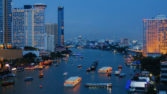 在金融区和摩天大楼的交通概念中在ChaoPhraya河的曲线上搭乘船只城市曼谷泰国区夜间图片