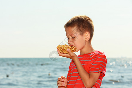 小男孩在户外吃甜食男孩在阳光的天气里享受着外面的甜点图片