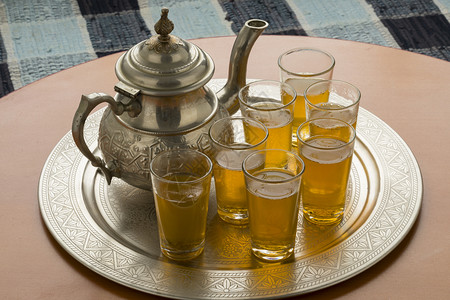 桌上有茶壶和杯的传统摩洛哥托盘图片