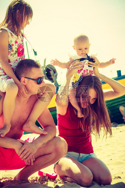 快乐的家庭在海滩上玩家庭在海边滩上摆姿势图片