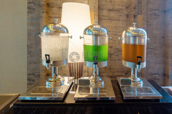 饮用水瓜瓦和橙汁在水冷却器中供早餐酒吧自我服务研讨会的客人使用图片
