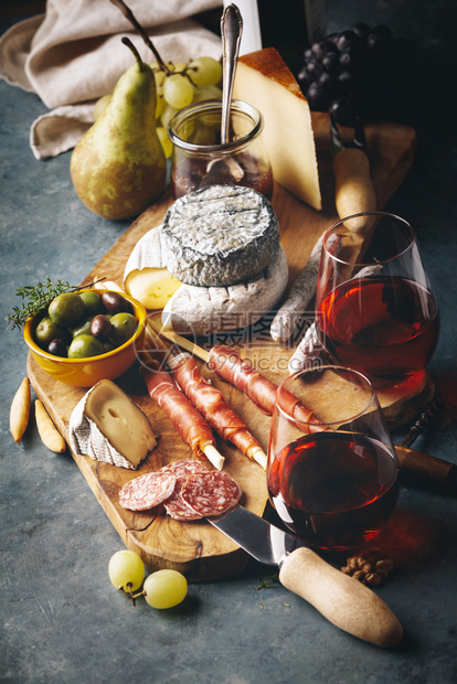 红葡萄酒石头背景上加料理的花样葡萄酒和零食图片