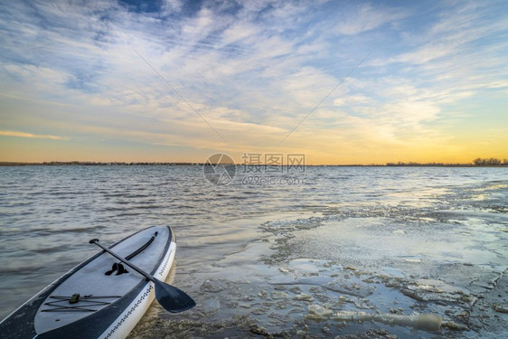 在北科普拉多的博伊德湖冰冷岸上站起桨板图片