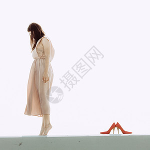 时装和趋势概念穿着长裙站立赤脚高跟鞋站在她旁边的妇女图片
