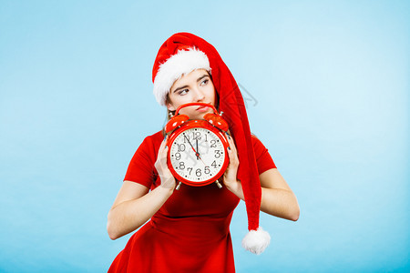 穿着圣诞老人帮手服装的妇女穿着圣诞老人的服装穿着红色大钟等庆祝图片