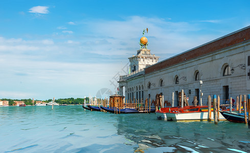 在威尼斯SantaMariadellaSalute的Basilica附近有停泊的Gondolas码头和船只图片