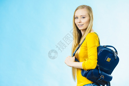 穿着时装背包上学或大的金发少女穿着时装背包上学或大配有时装饰品穿蓝色带背包的少女图片