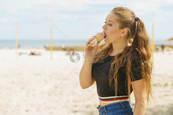 快乐的年轻女孩长棕色头发吃冰淇淋玩得开心年轻女孩吃冰淇淋图片