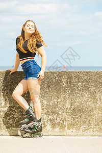 在户外穿溜冰鞋的年轻女子在阳光明媚的夏日玩得开心时装合身女孩在户外穿溜冰鞋的合适女孩图片