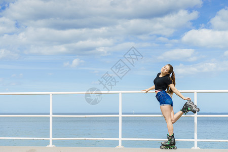 快乐的年轻女子穿着滑冰鞋在长途旅行后放松快乐的年轻女子穿着滚冰鞋图片
