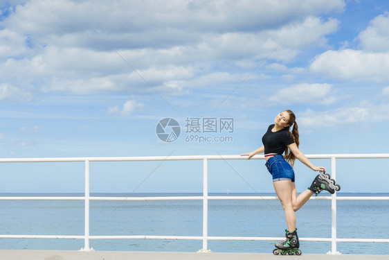 快乐的年轻女子穿着滑冰鞋在长途旅行后放松快乐的年轻女子穿着滚冰鞋图片