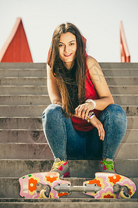 酷酷的滑板女孩坐在台阶上休息
图片