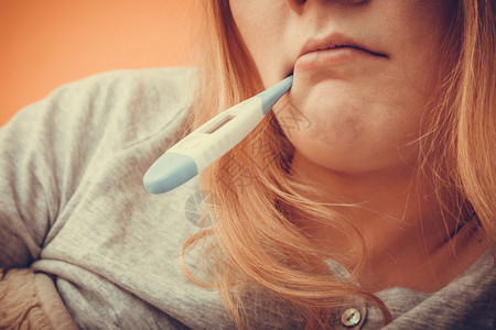 口腔内有数字温度计的患病妇女温度测量高的少女健康口腔内有数字温度