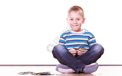 小男孩坐在地上玩游戏牌图片