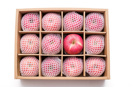 粒子光线冲击白色背景孤立的纸箱内有防冲击泡沫网包装的红色苹果背景